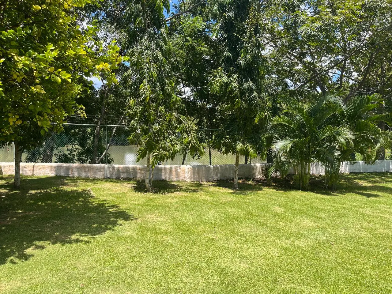 The garden opening onto the lake — lakeside home for sale at Club Ecuestre de Coronado, Panama
