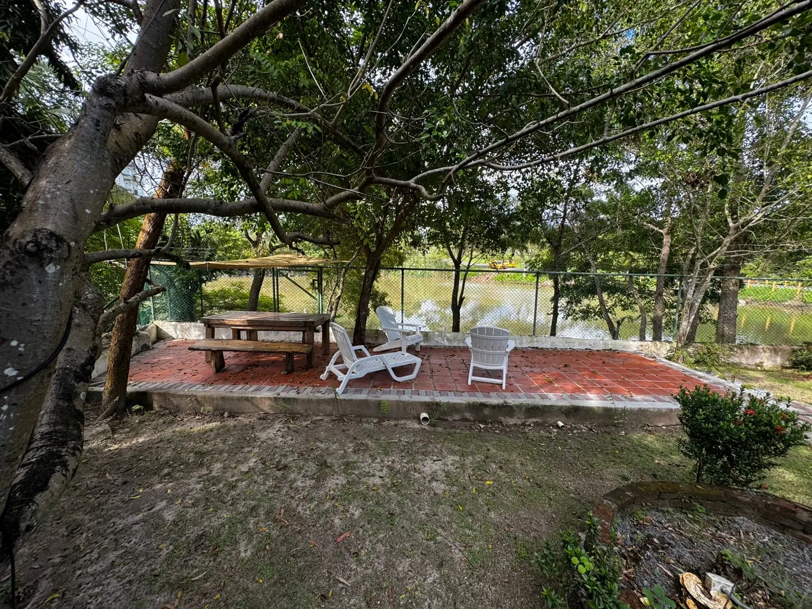 The terrace under the trees by the lake — lakeside home for sale at Club Ecuestre de Coronado, Panama