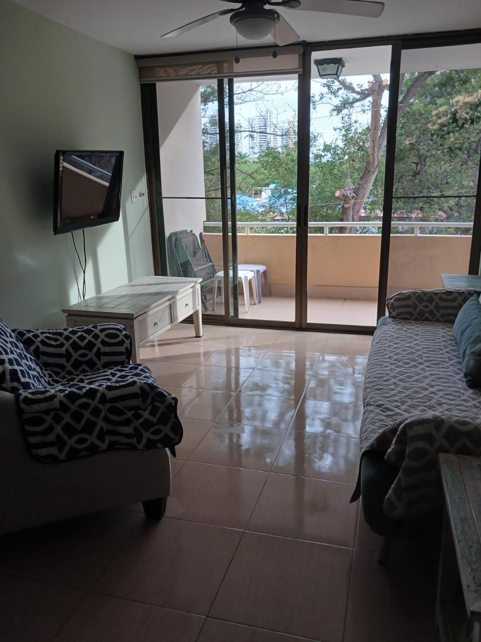 Living room view toward balcony and trees