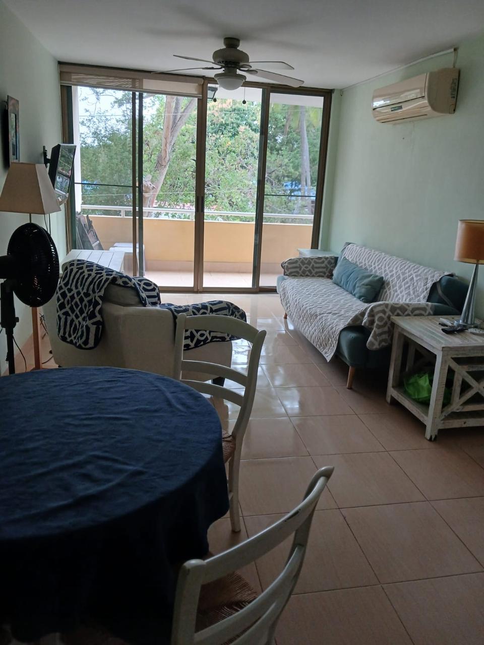 Bright living room with ceiling fan, air-conditioning, and balcony access