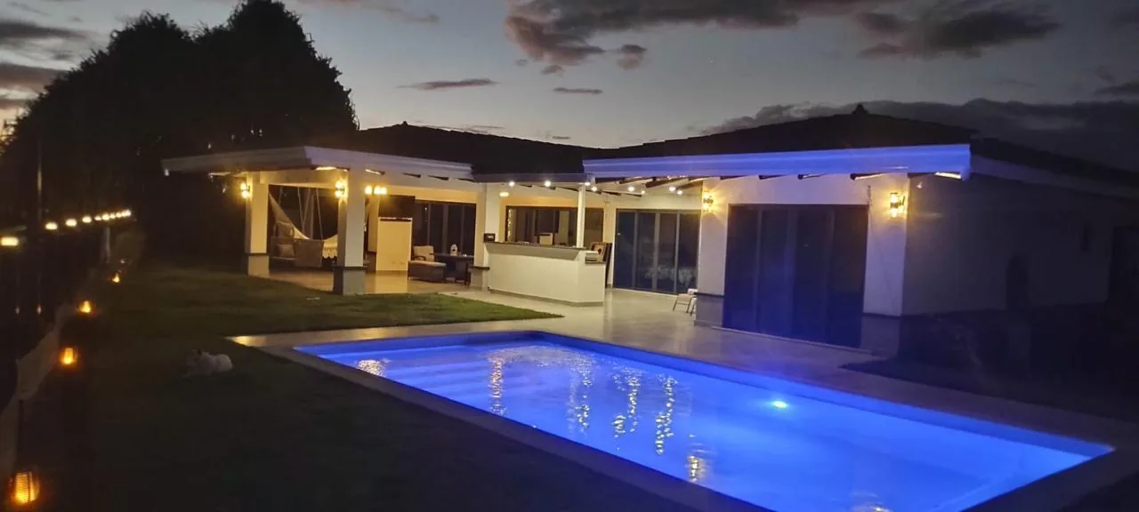 Pool and terrace lit at night — ocean-view home for sale in Terrazas de Vista Mar, San Carlos, Panama